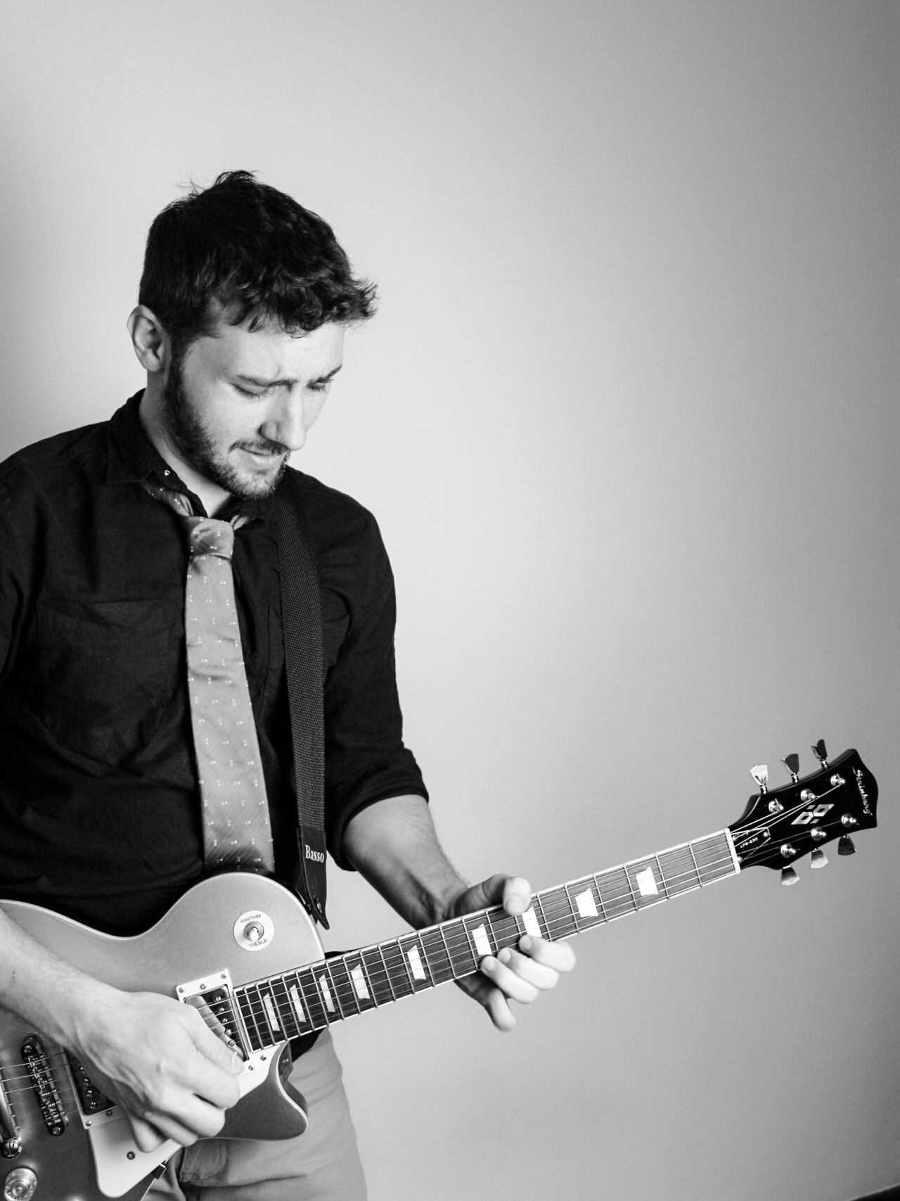 Retrato em preto e branco de Roger Loeblein com uma guitarra elétrica