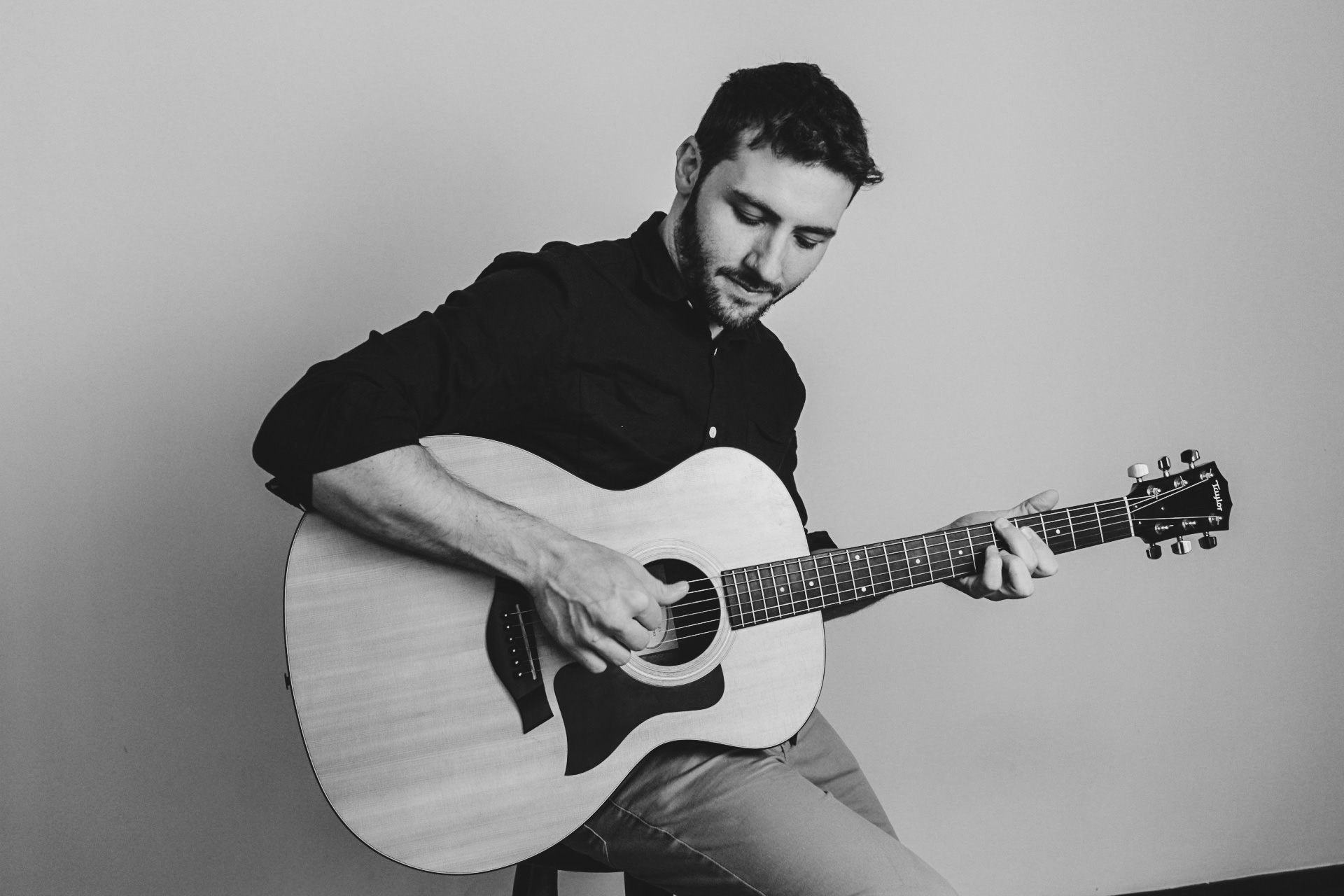 Roger Loeblein tocando violão em estúdio, fotografia em preto e branco